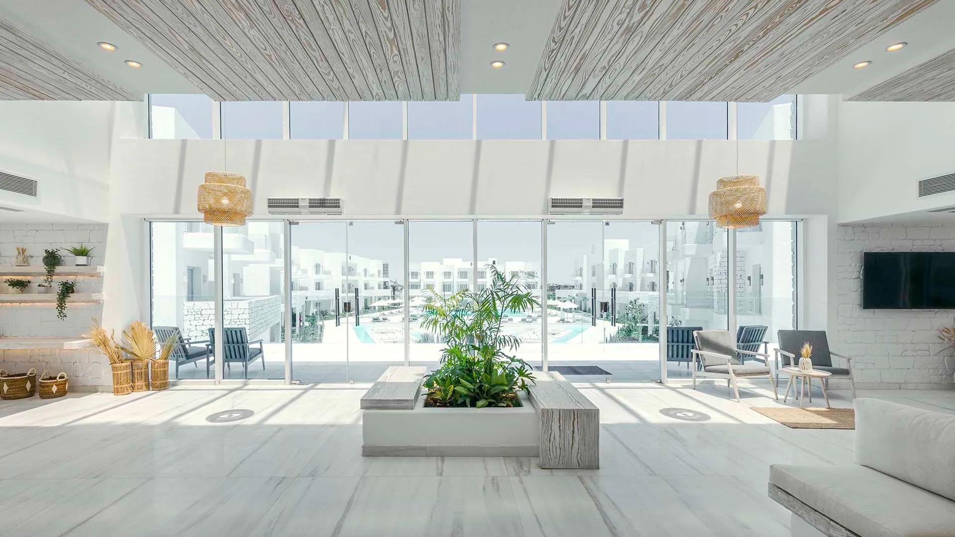 A Large Room With A Large Glass Wall And A Large Planter