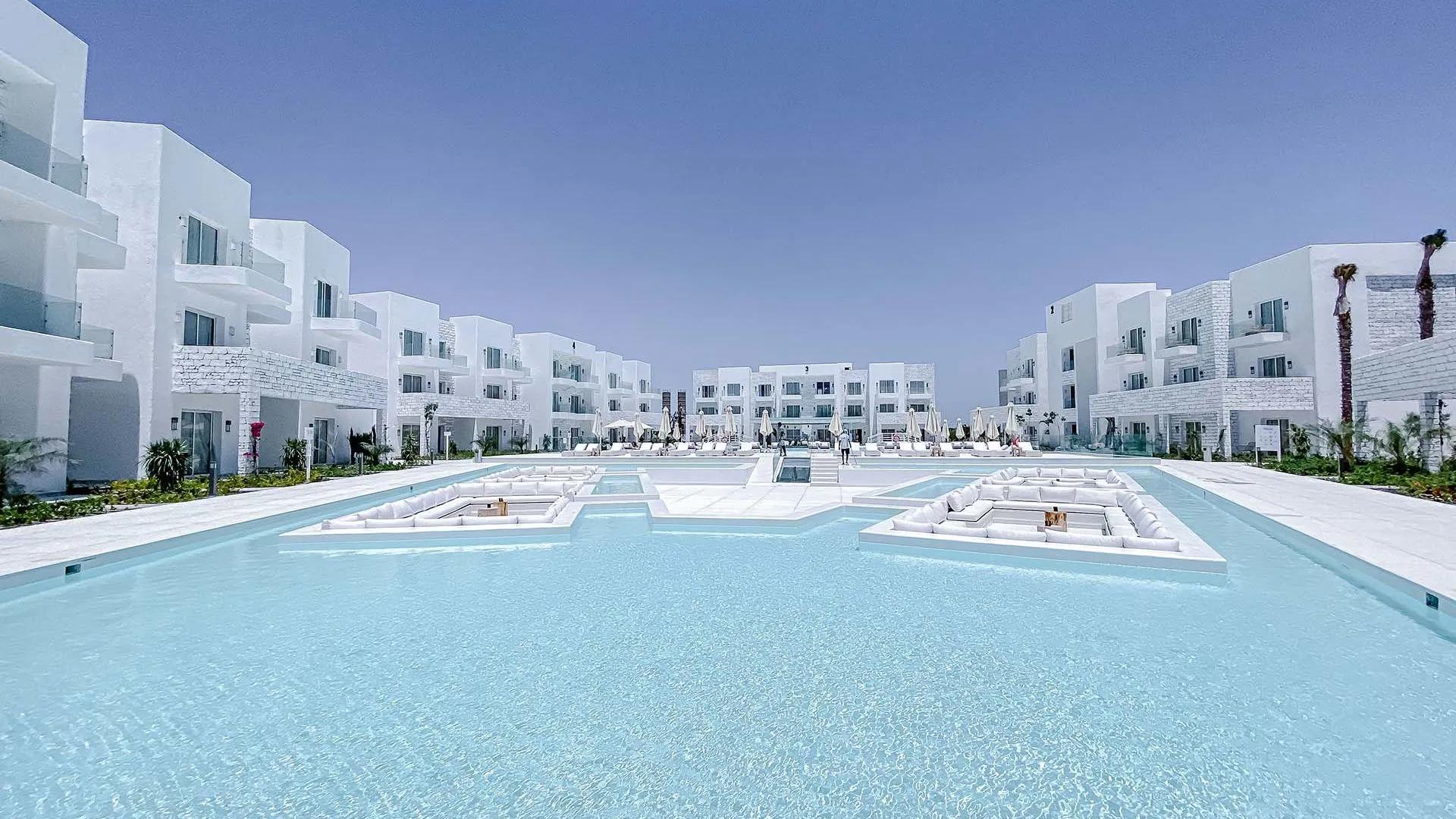 A Pool In Front Of A Large White Building