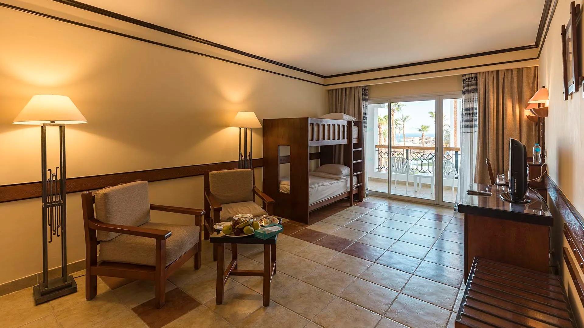 A Bedroom With A Bed And Chairs