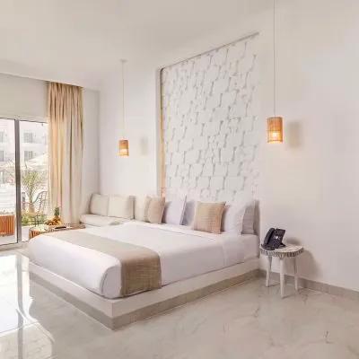 A Large White Room With A Large Glass Door And A Large White Bed