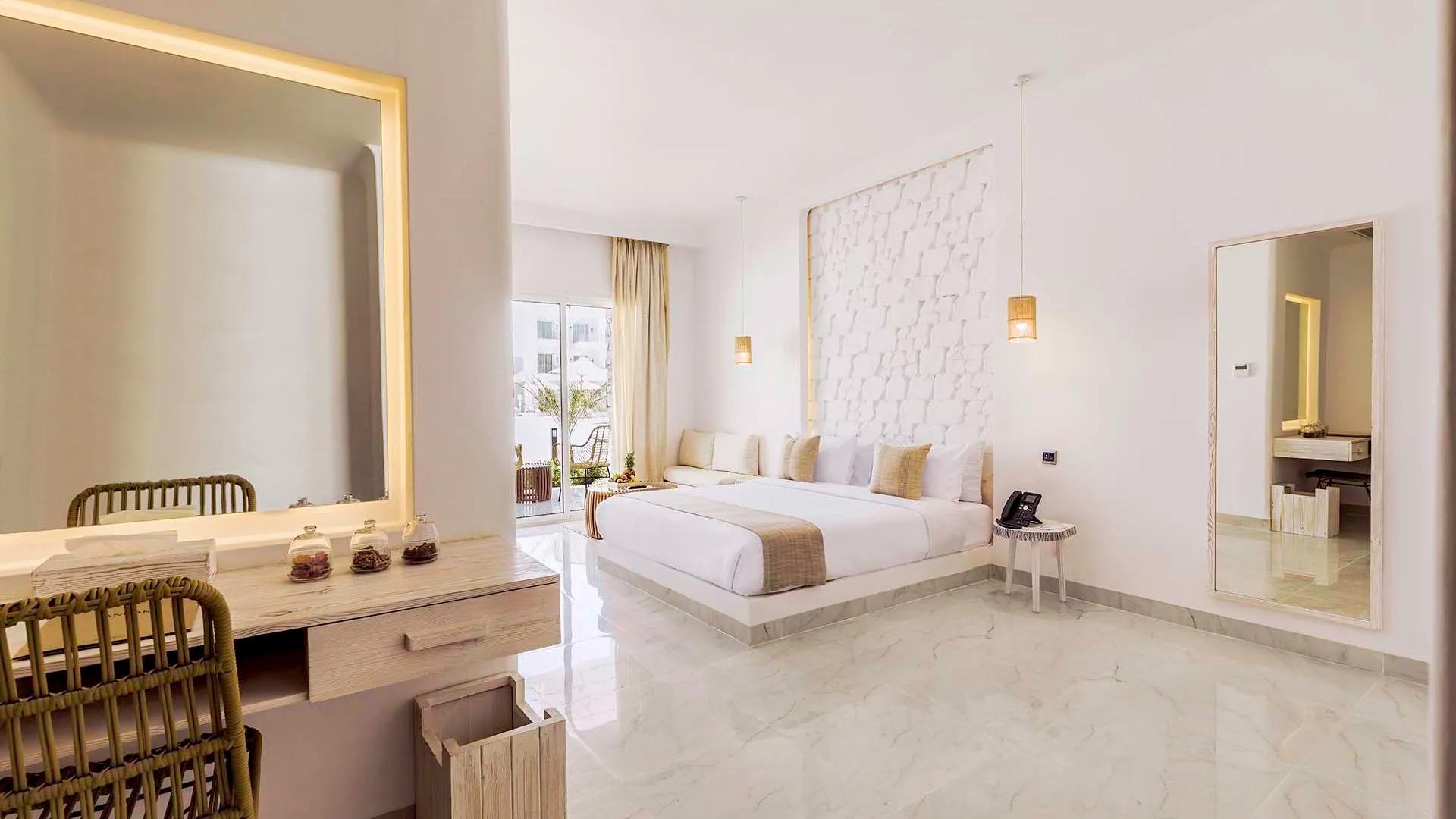 A Large Bedroom With A Large Mirror