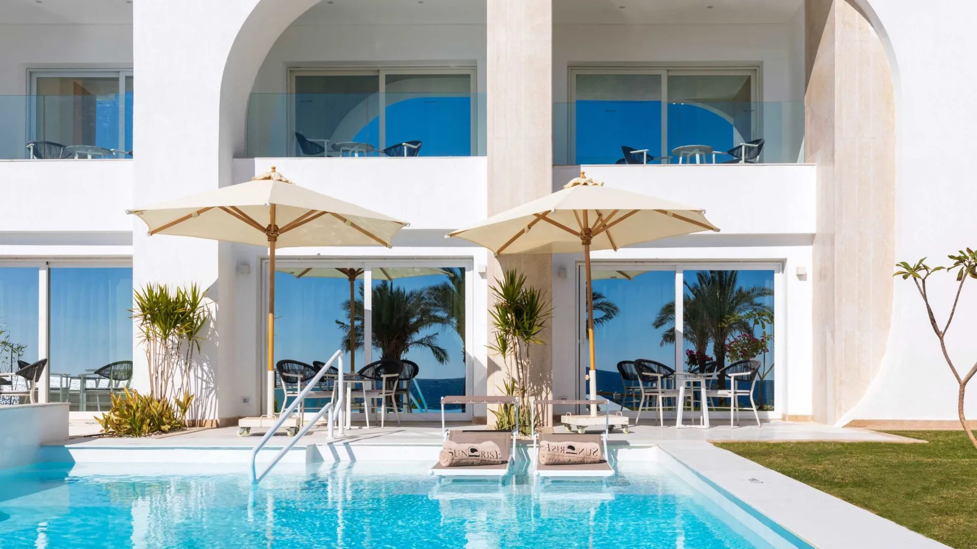 A Pool With Umbrellas And Chairs