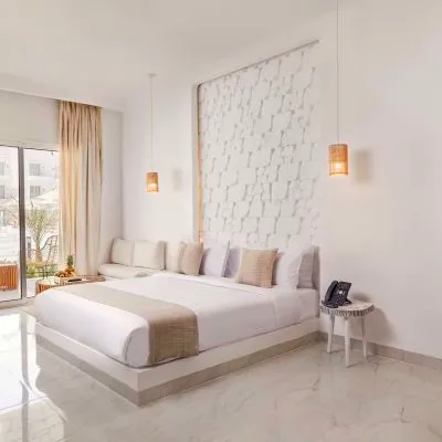 A Large White Room With A Large Glass Door And A Large White Bed