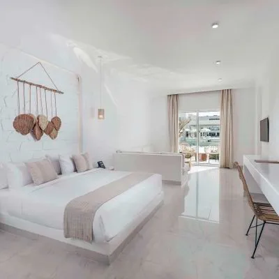 A Large White Room With A Bed And A Table