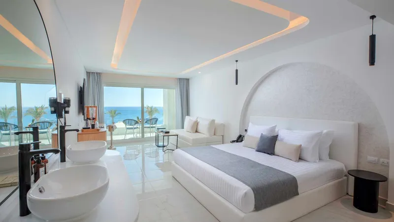 A Bedroom With A Large Bed And A Large Window